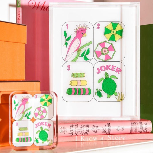 Children's card game with colorful cards featuring animals and a 'Joker' card, placed on top of books.