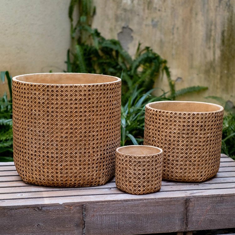 Three woven baskets of different sizes on a wooden surface with a natural background.